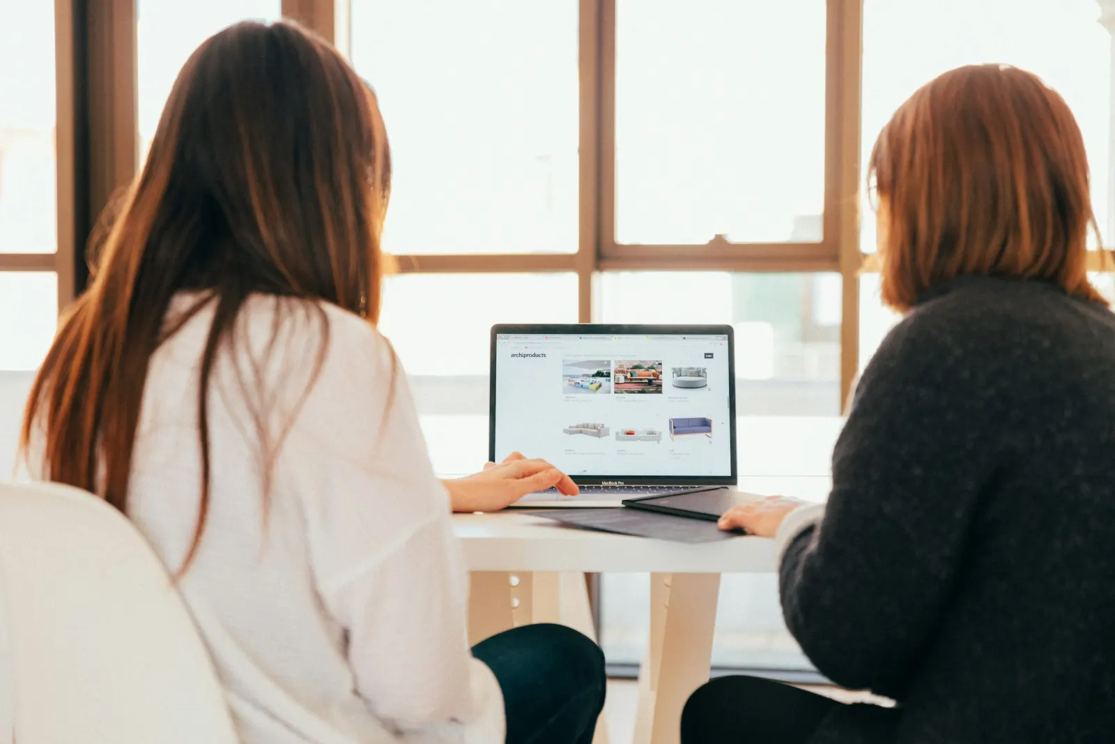 Two business owners reviewing a website on a laptop