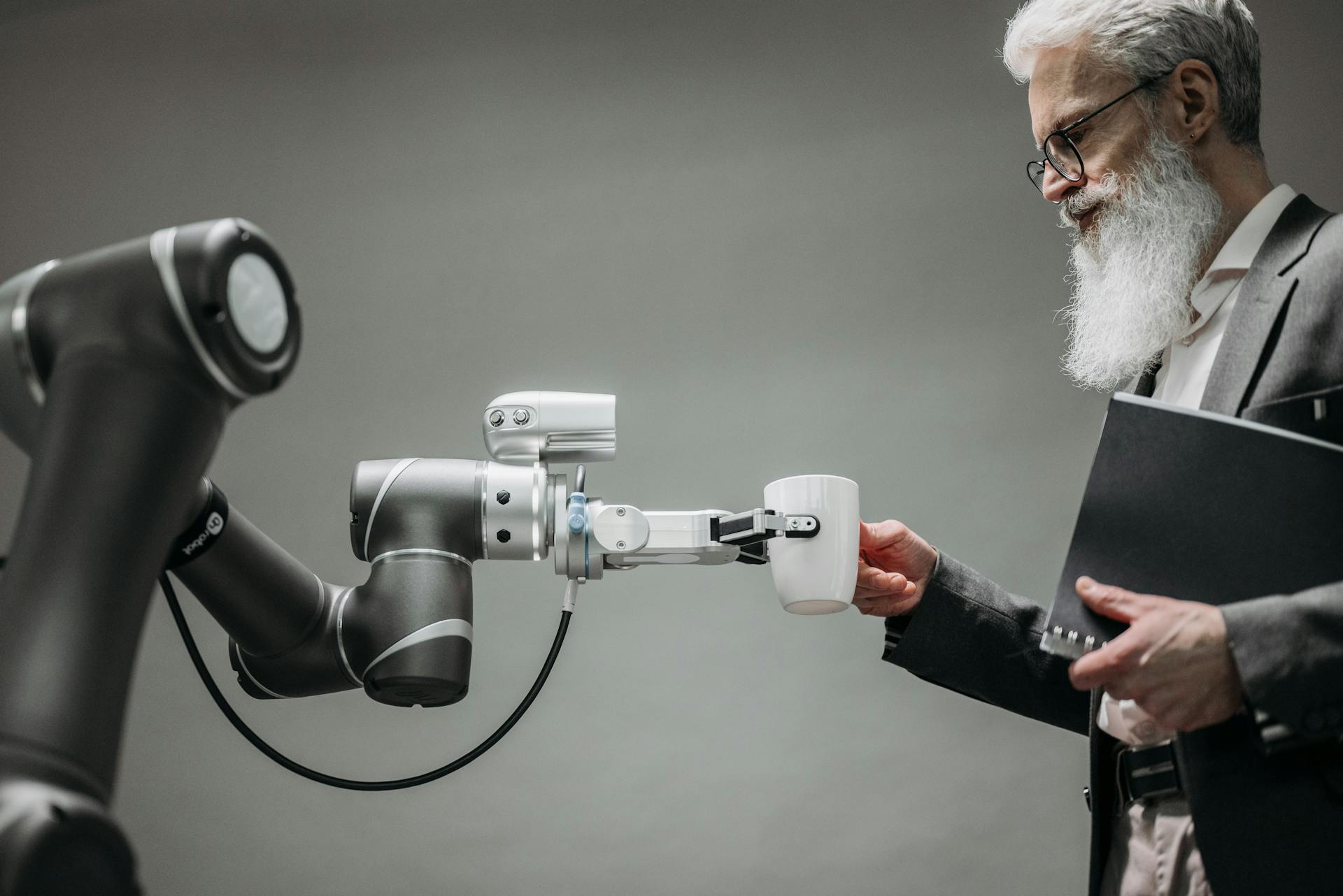 An image of a man with robot handing him a glass of water